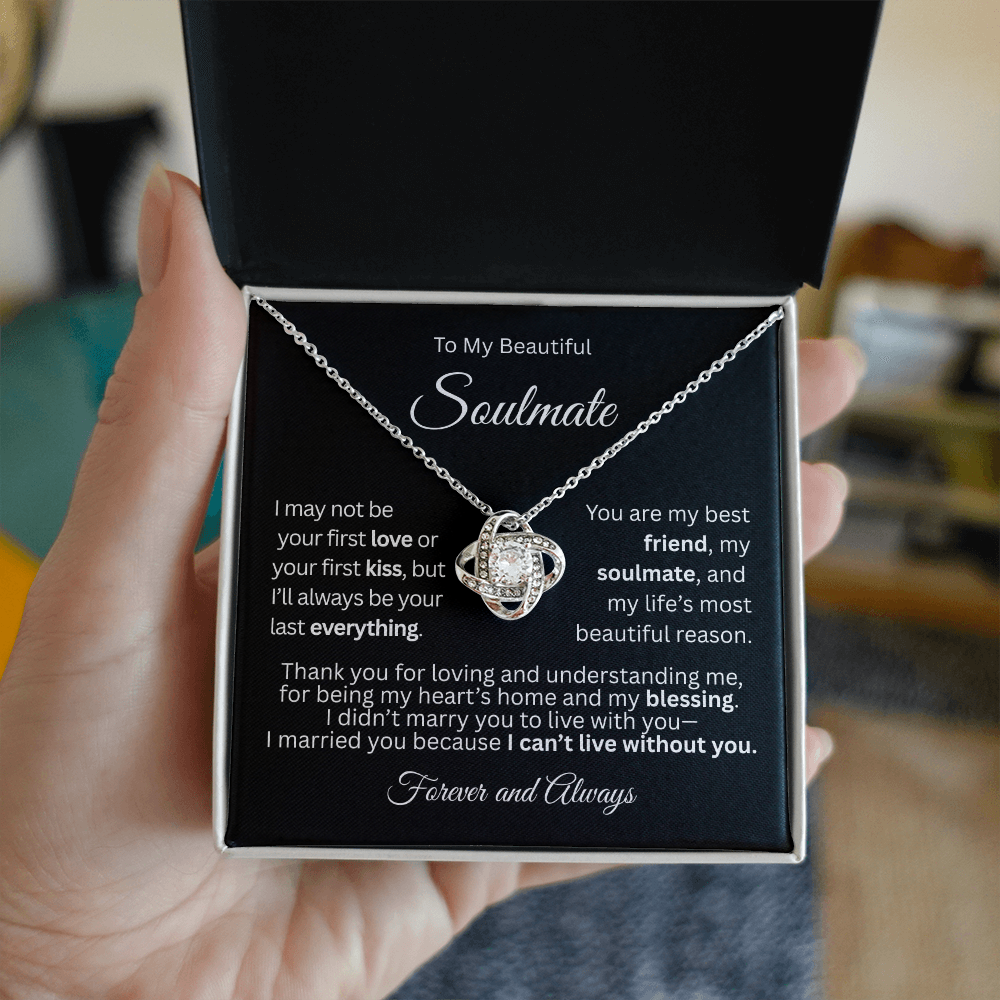 White gold love knot necklace in a white gift box with a heartfelt “To My Beautiful Soulmate” message card, held in a woman's hand.